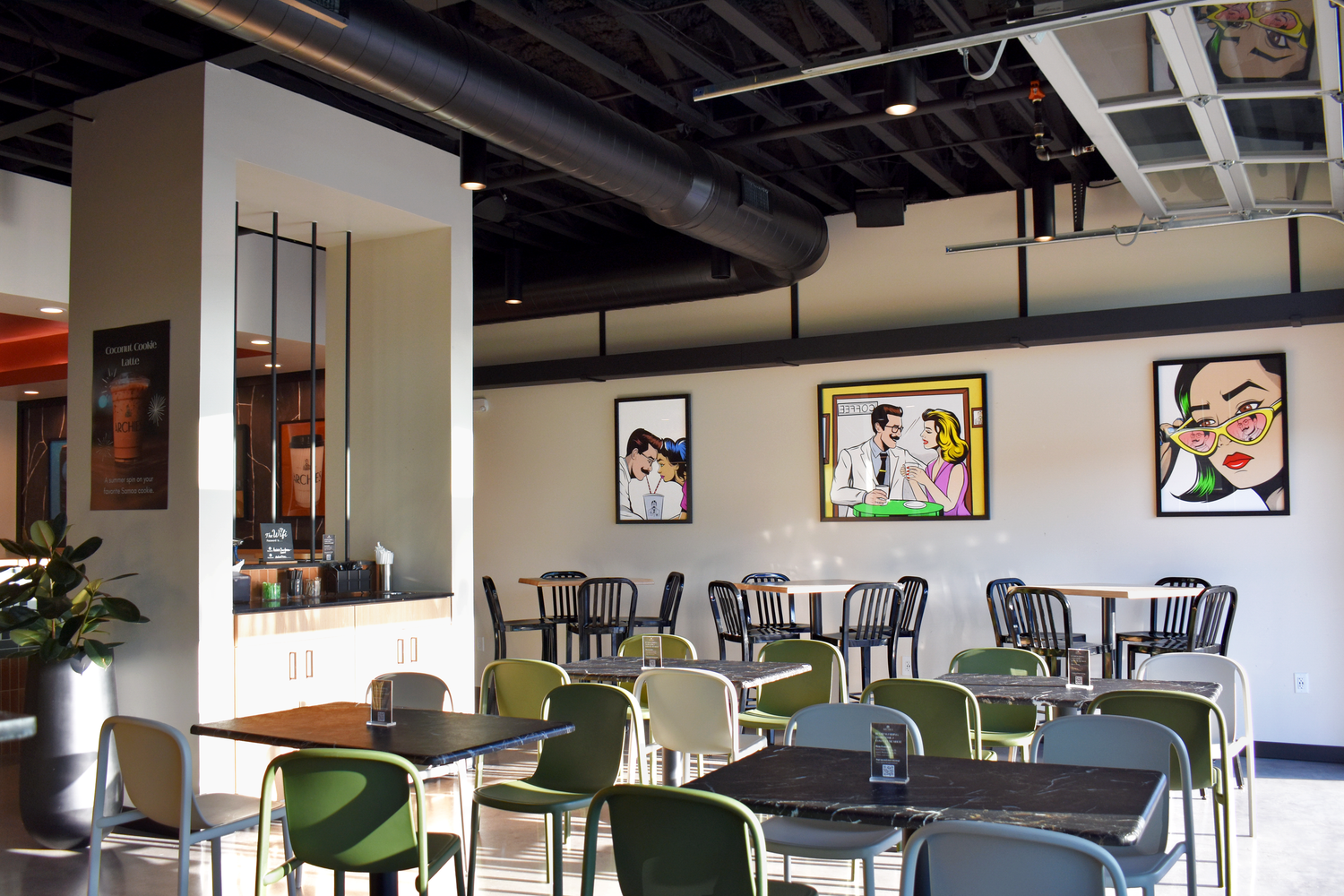 Archies Fine Coffee lounge dining area in San Antonio with curated pop art gallery wall and open ceiling