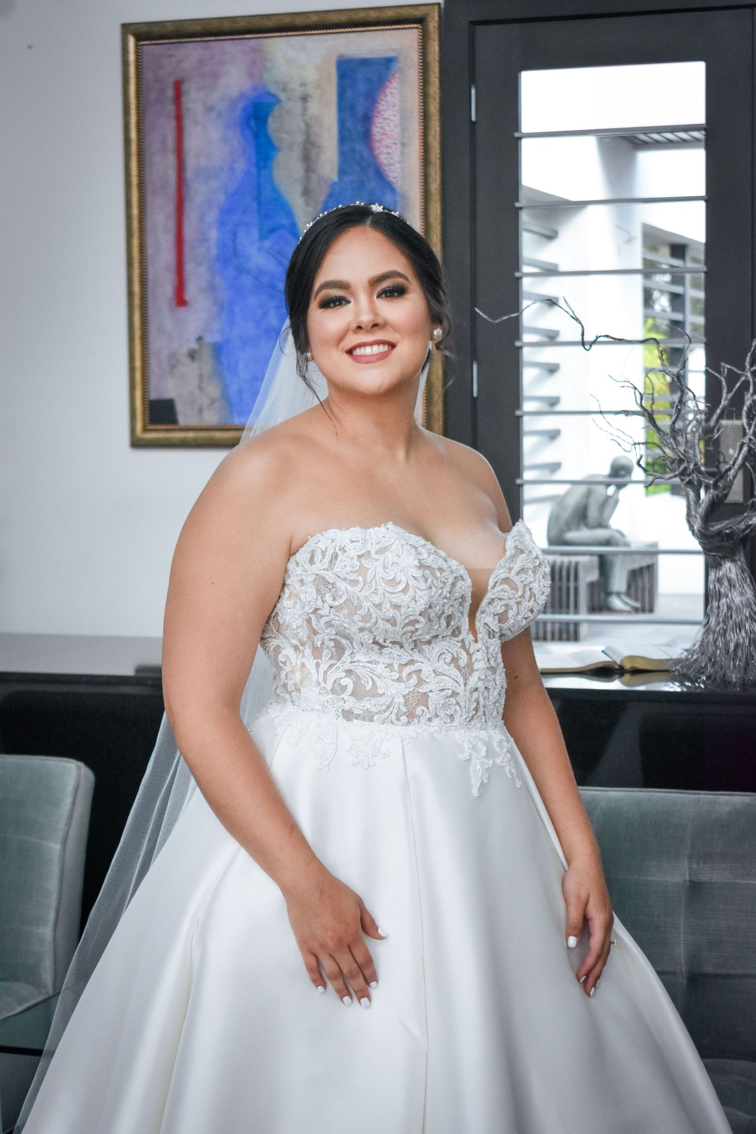 Bridal portrait in Brownsville Texas with bride in beaded lace ballgown smiling indoors