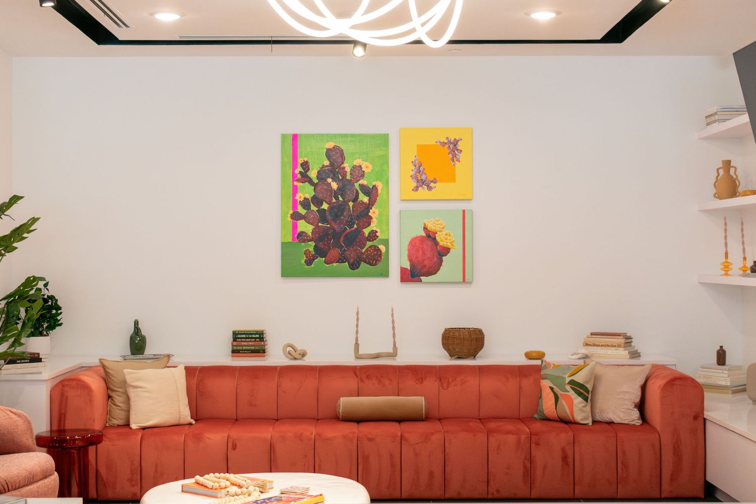 Living room interior at The Continental Residences in downtown San Antonio with curated cactus artwork and modern chandelier