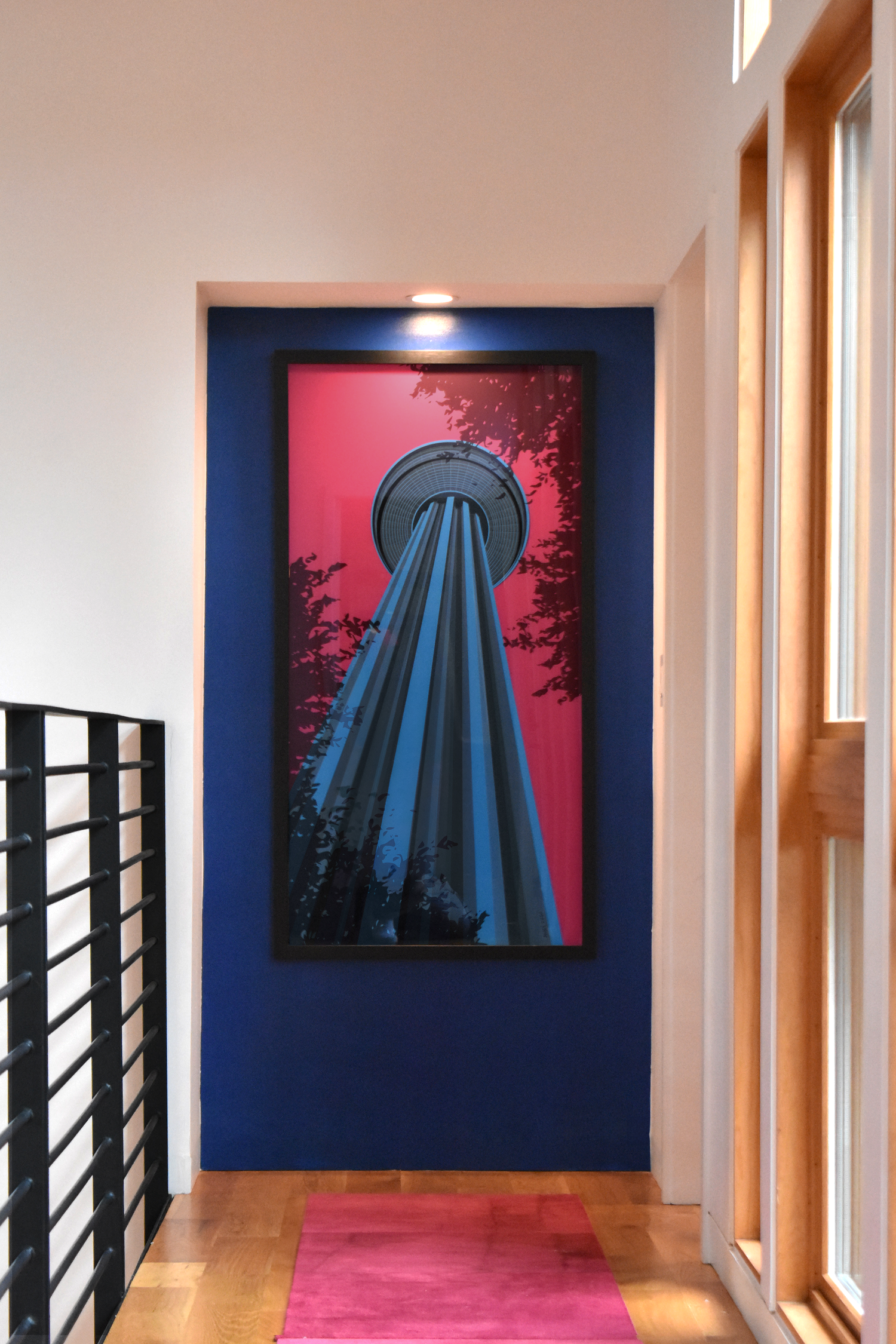 Residential hallway in downtown San Antonio with bold blue accent wall and curated tower artwork