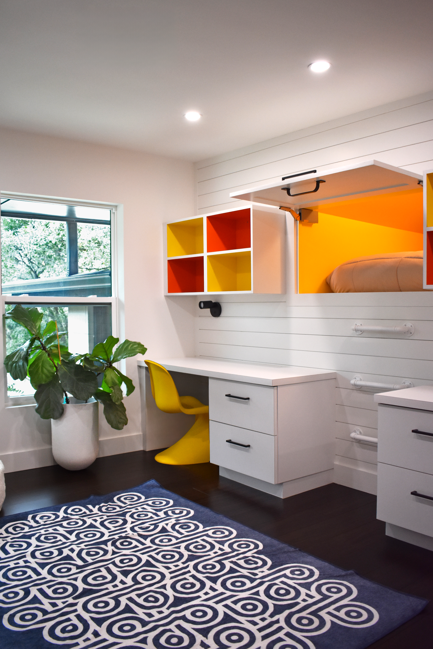 Residential kids bedroom interior in San Antonio with built-in desk and colorful shelving