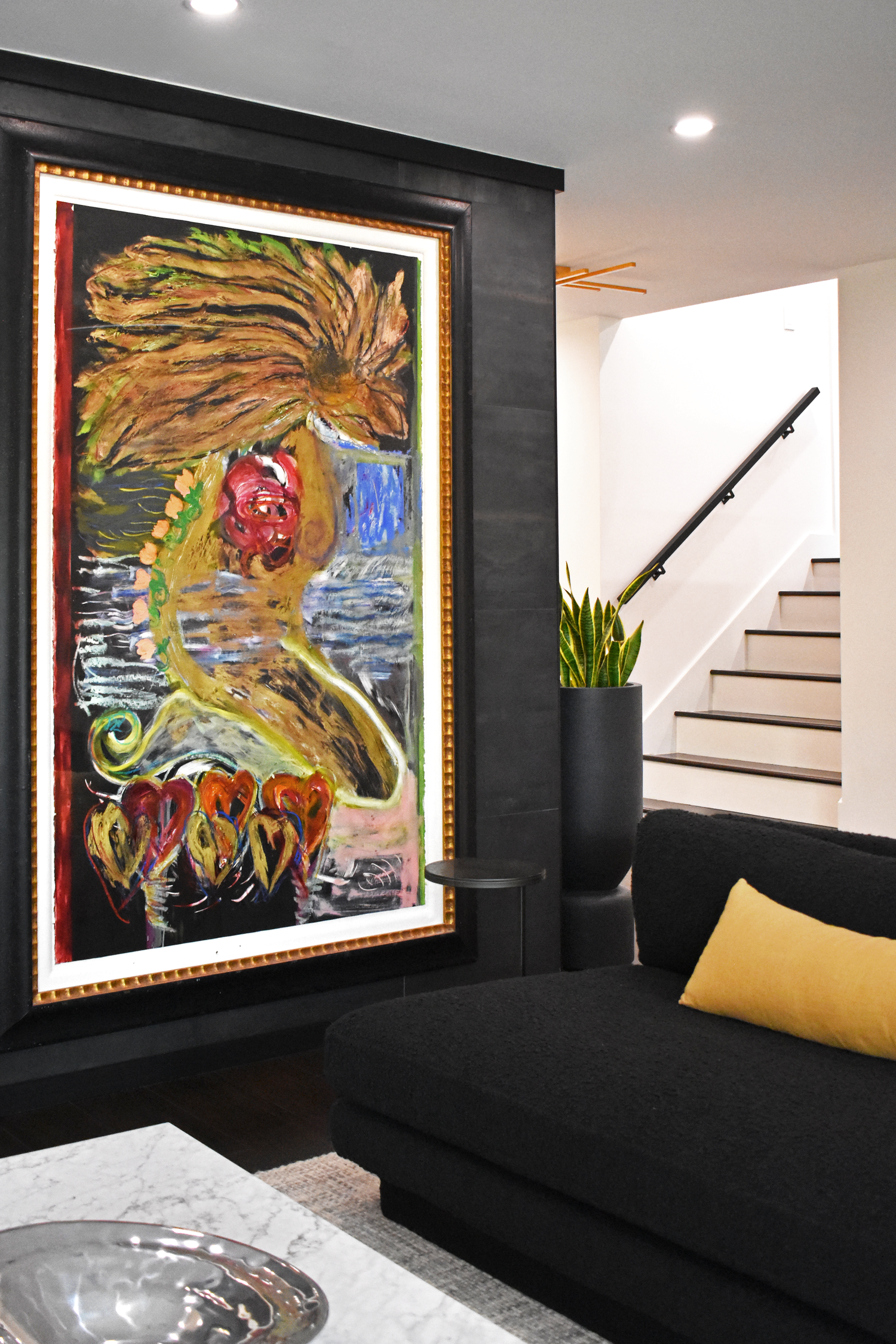 Residential living room interior in San Antonio with bold large-scale curated artwork and black sofa