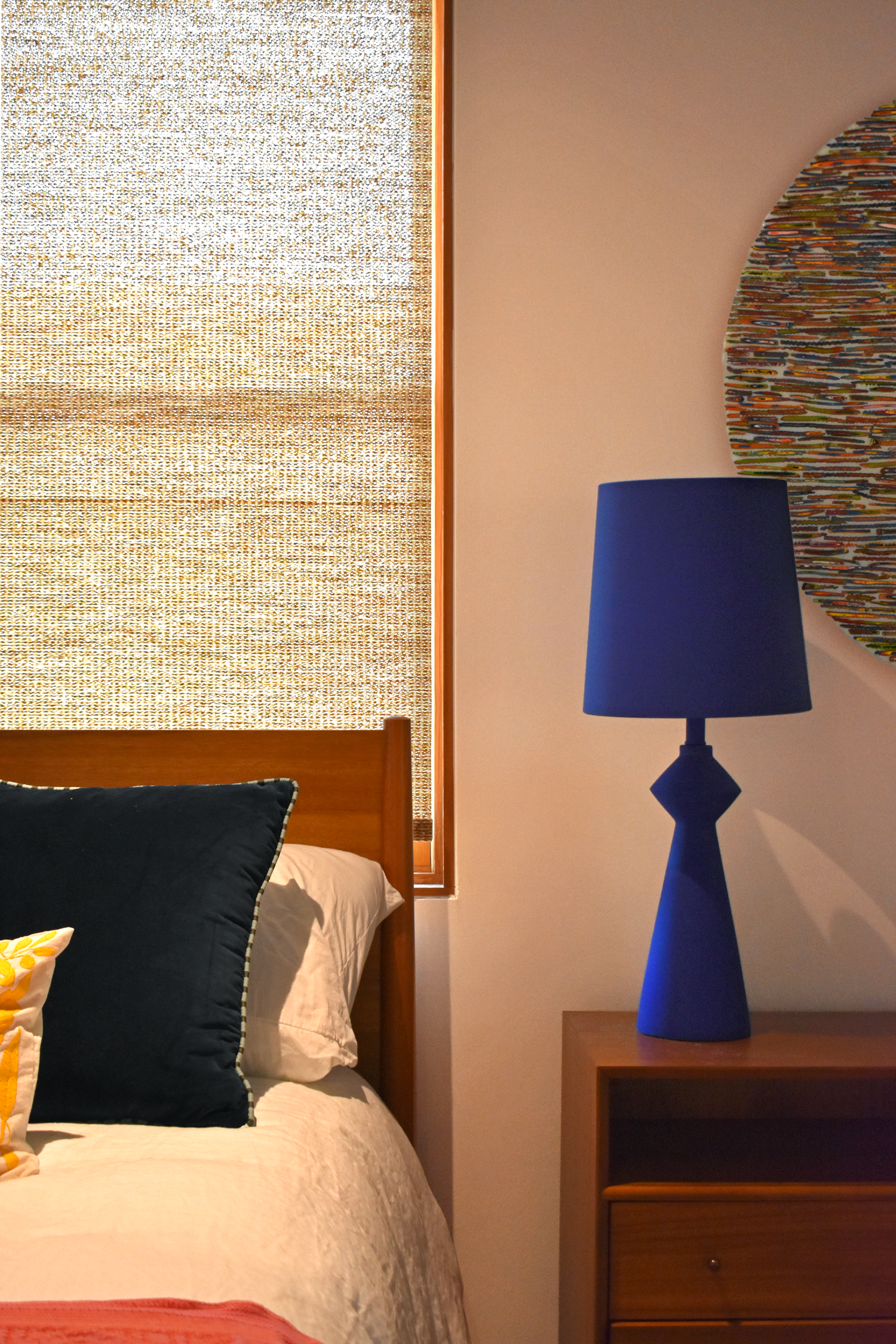 Residential bedroom interior in downtown San Antonio with blue lamp and curated circular wall art