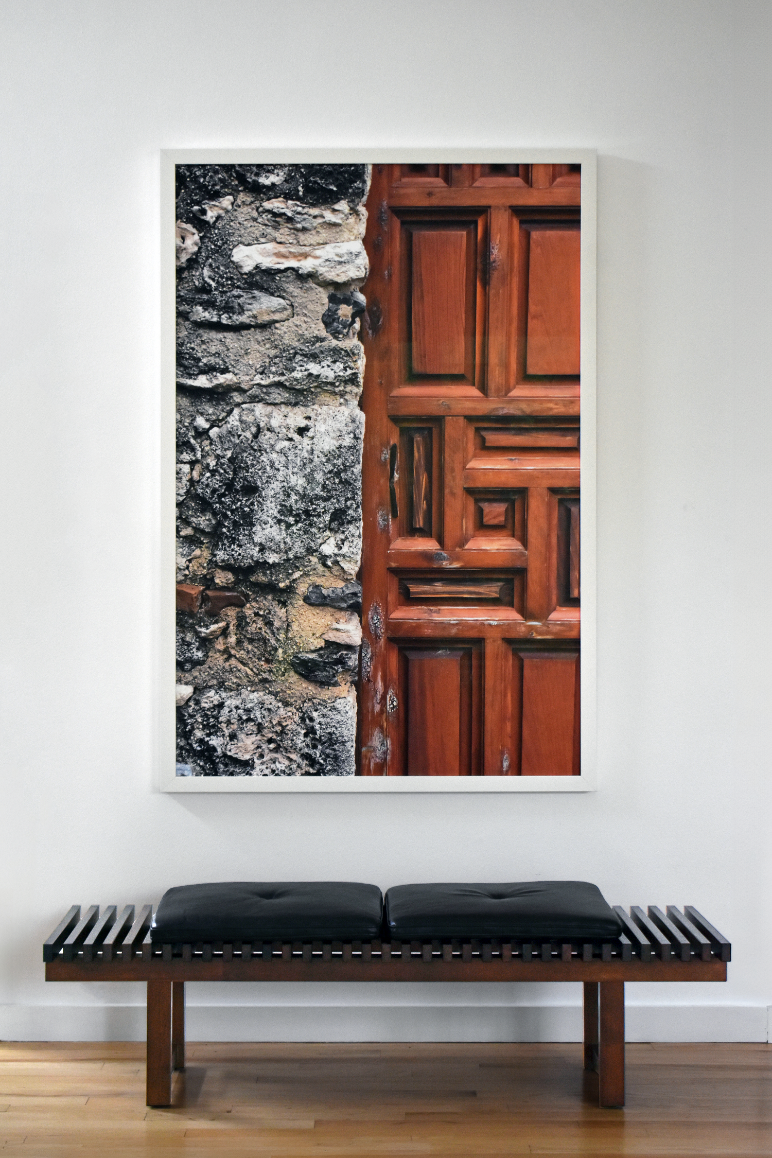 Residential interior in San Antonio with large curated rustic door and stone wall photography print