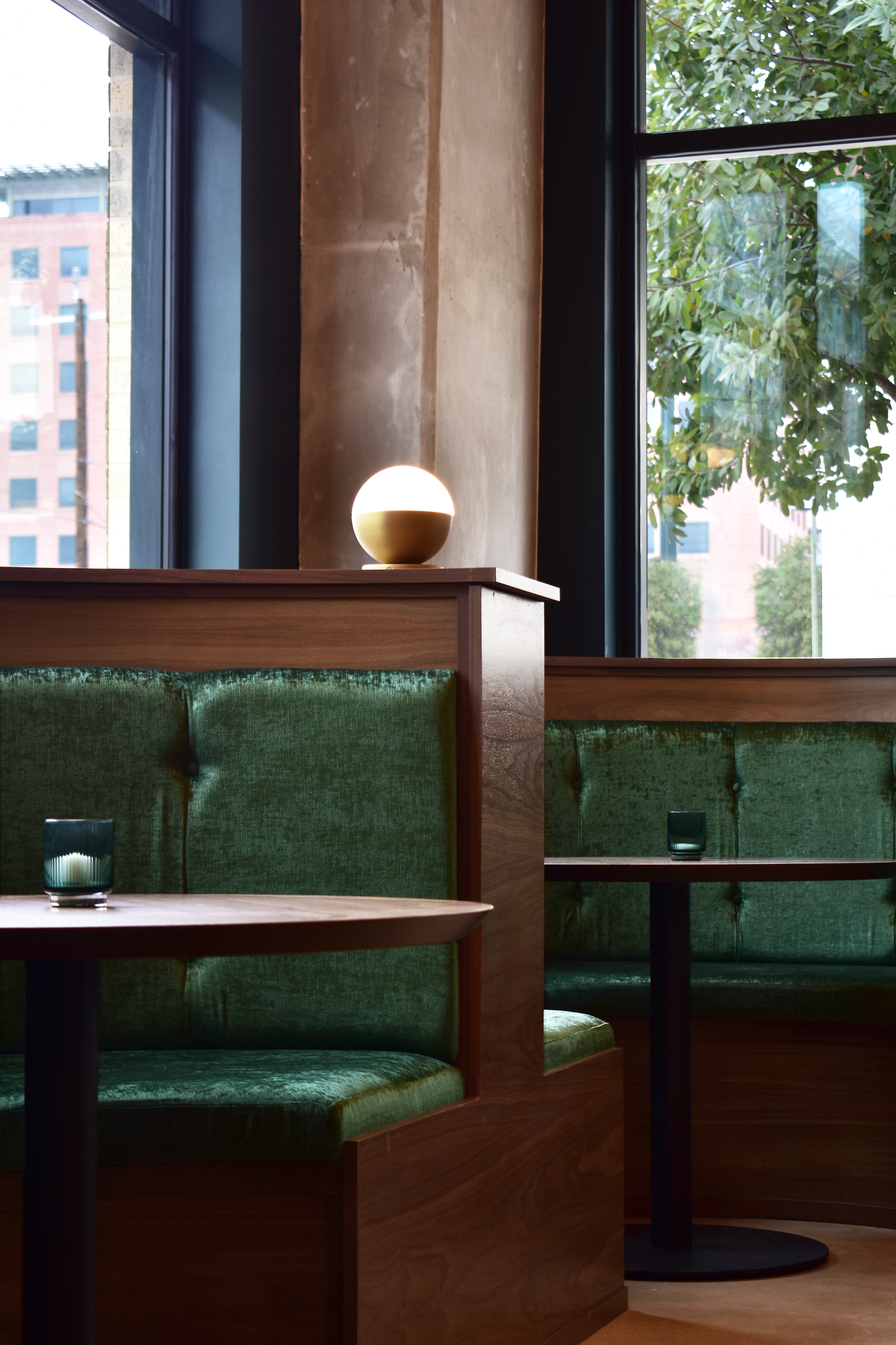 Kafe Krave interior in San Antonio with green velvet booth seating and natural window light