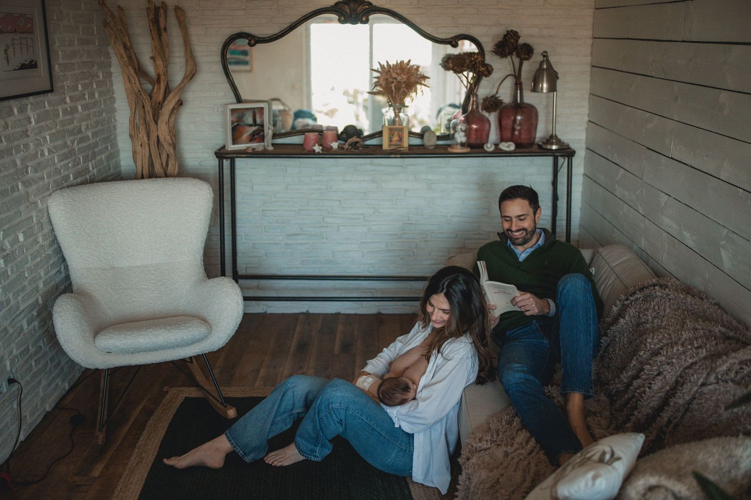 Couple relaxing together on living room floor looking at a tablet and smiling.