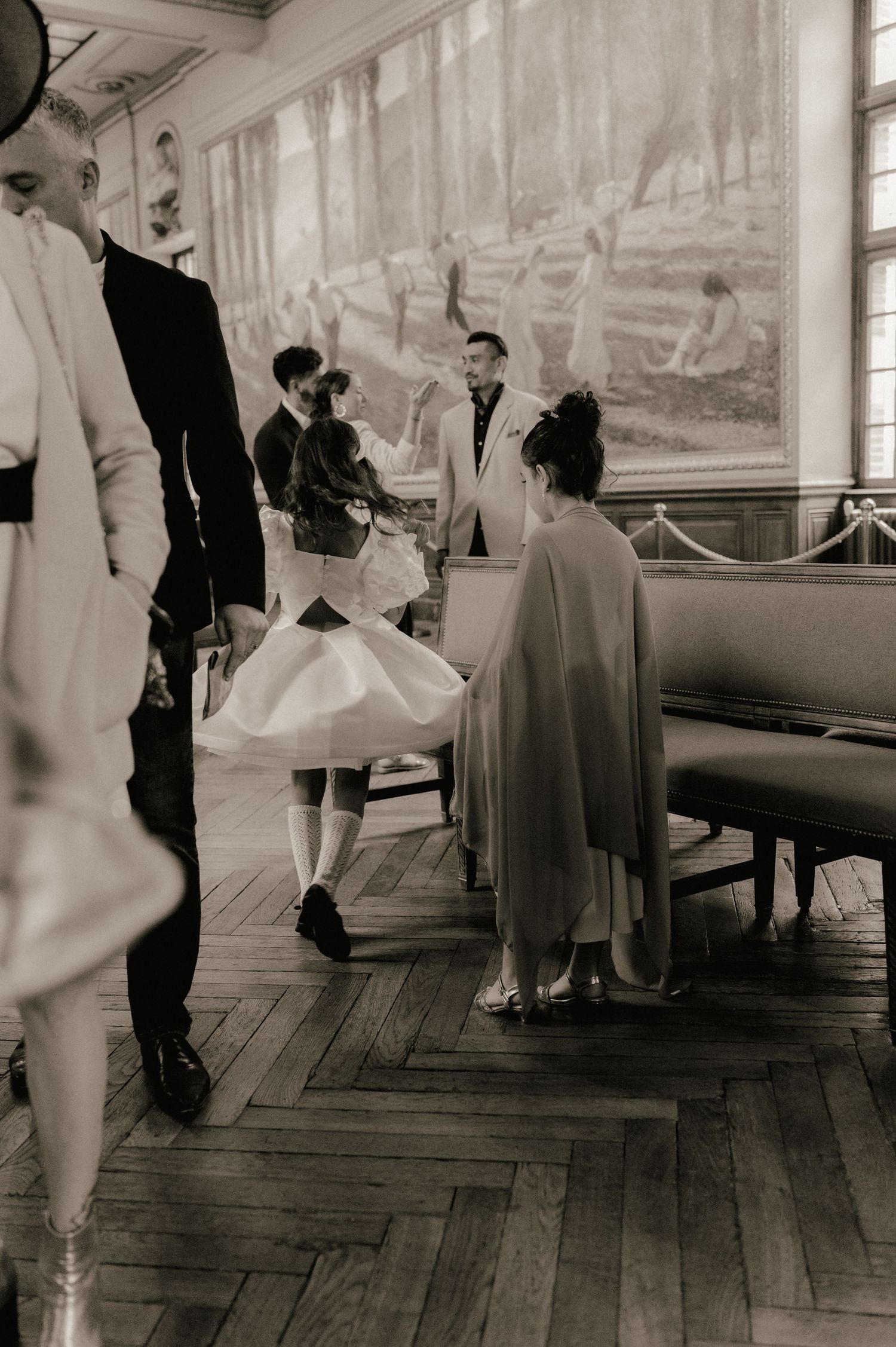Wedding guests gather in historic venue during ceremony, black and white photo.