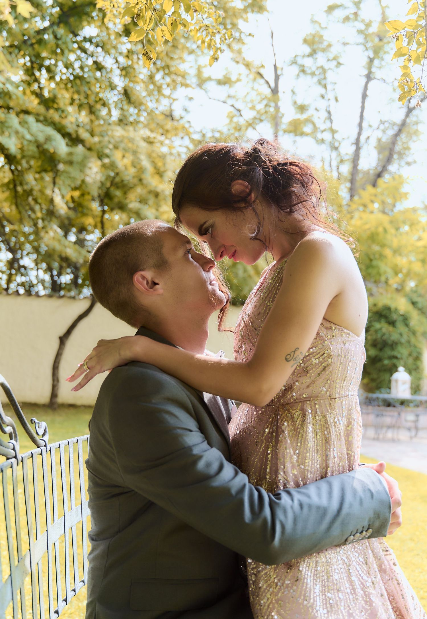 Couple sharing a tender romantic moment outdoors in autumn at their wedding celebration.