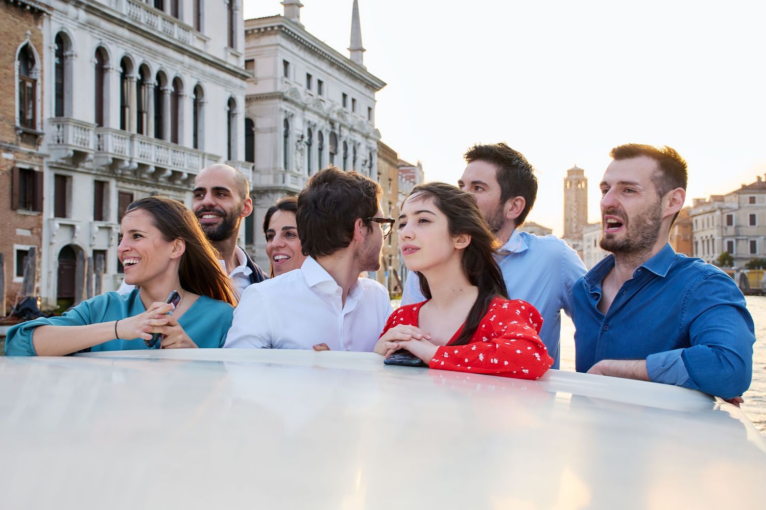 Group of friends enjoying a scenic boat ride along the Grand Canal in Venice.