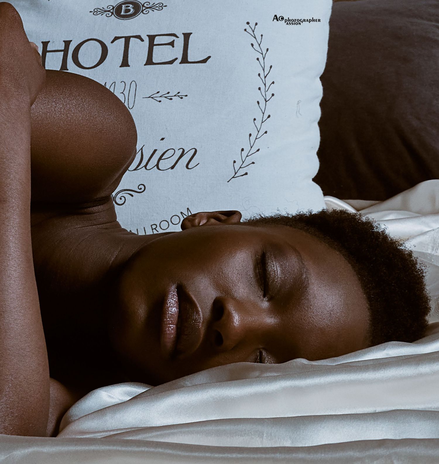 Person sleeping peacefully in a hotel bed with white pillows.