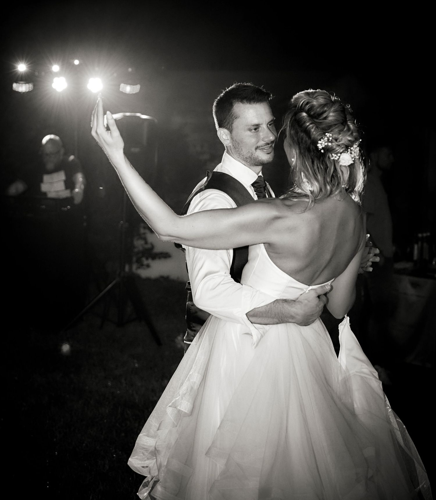 Bride and groom share first dance in black and white wedding photo.