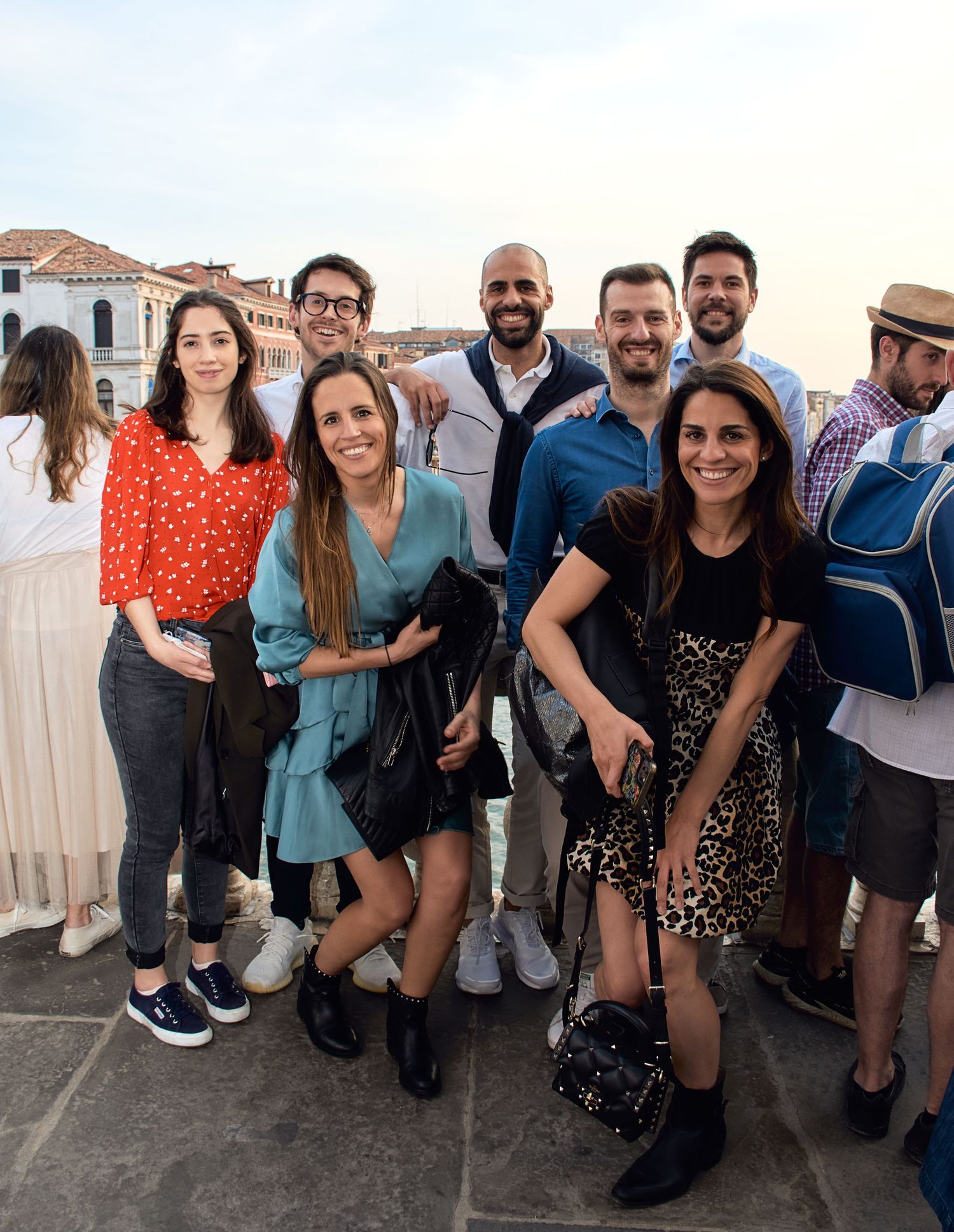 Group of friends posing together on a rooftop terrace in Venice at dusk.