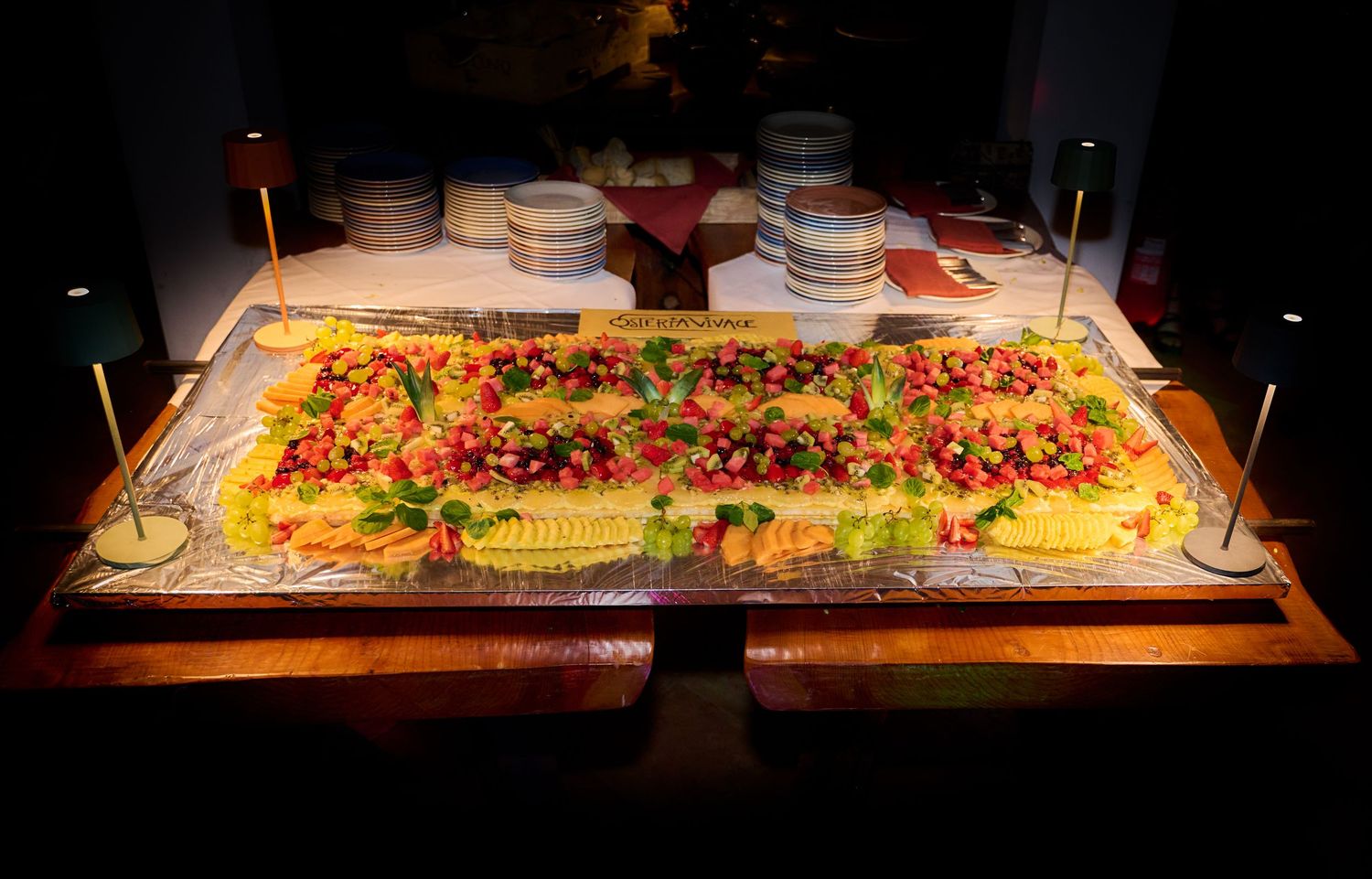 Large decorative food display with colorful toppings on a buffet table.