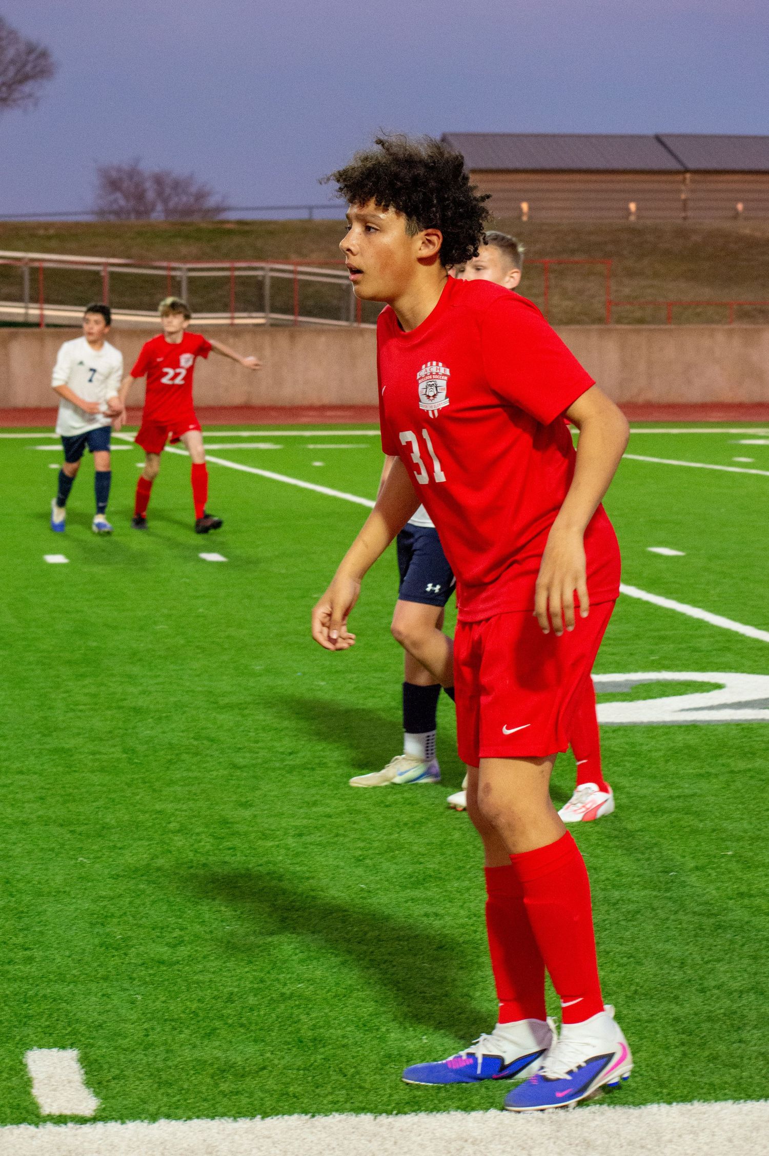 soccer player in red uniform standing on field during game