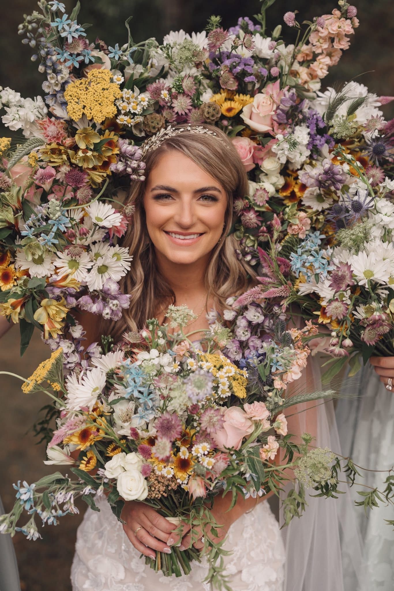 Colorful floral arrangements with pastel blooms and delicate wildflowers in a rustic wedding setting.