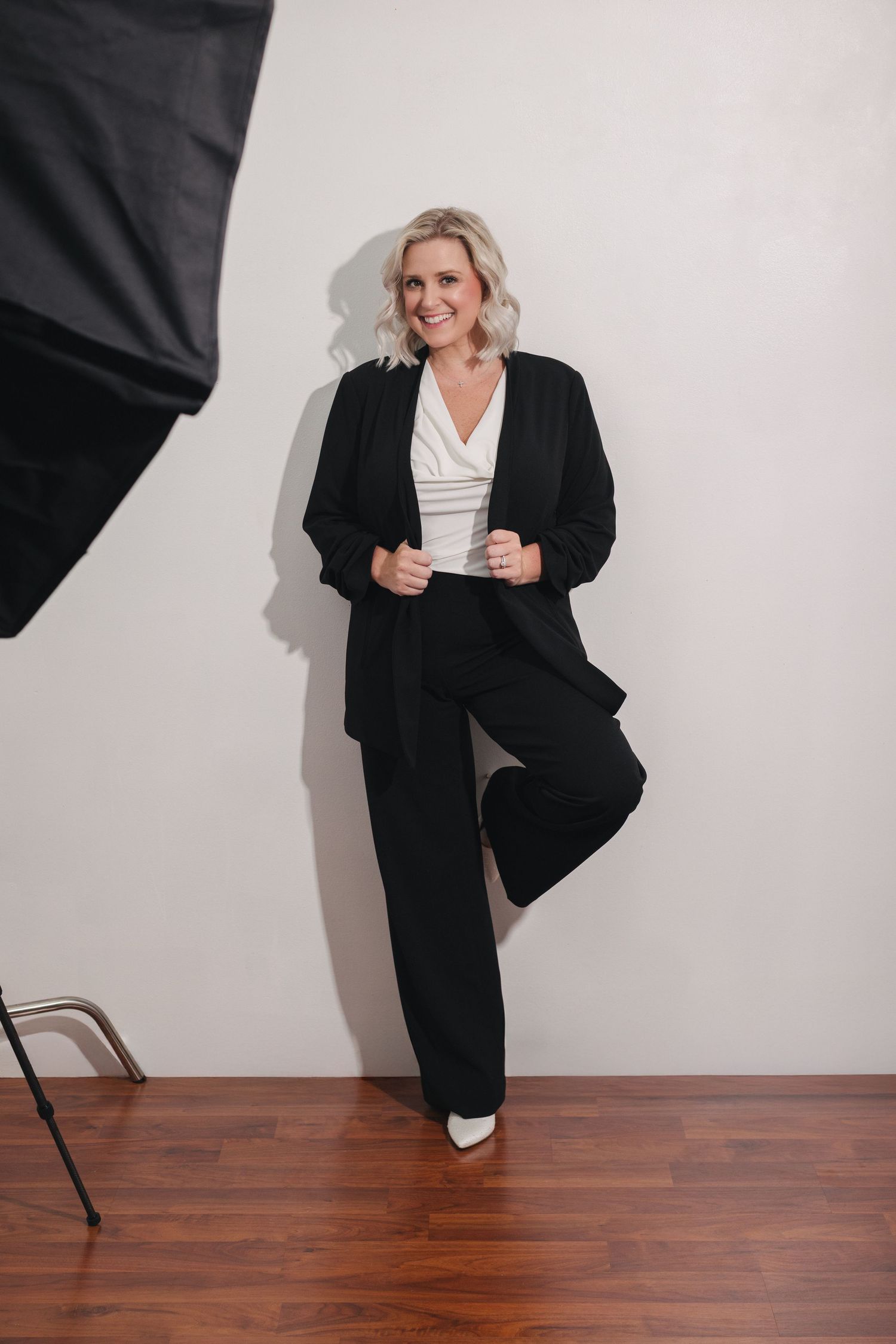 Professional studio portraits showing dynamic poses in black business attire against white backdrop.