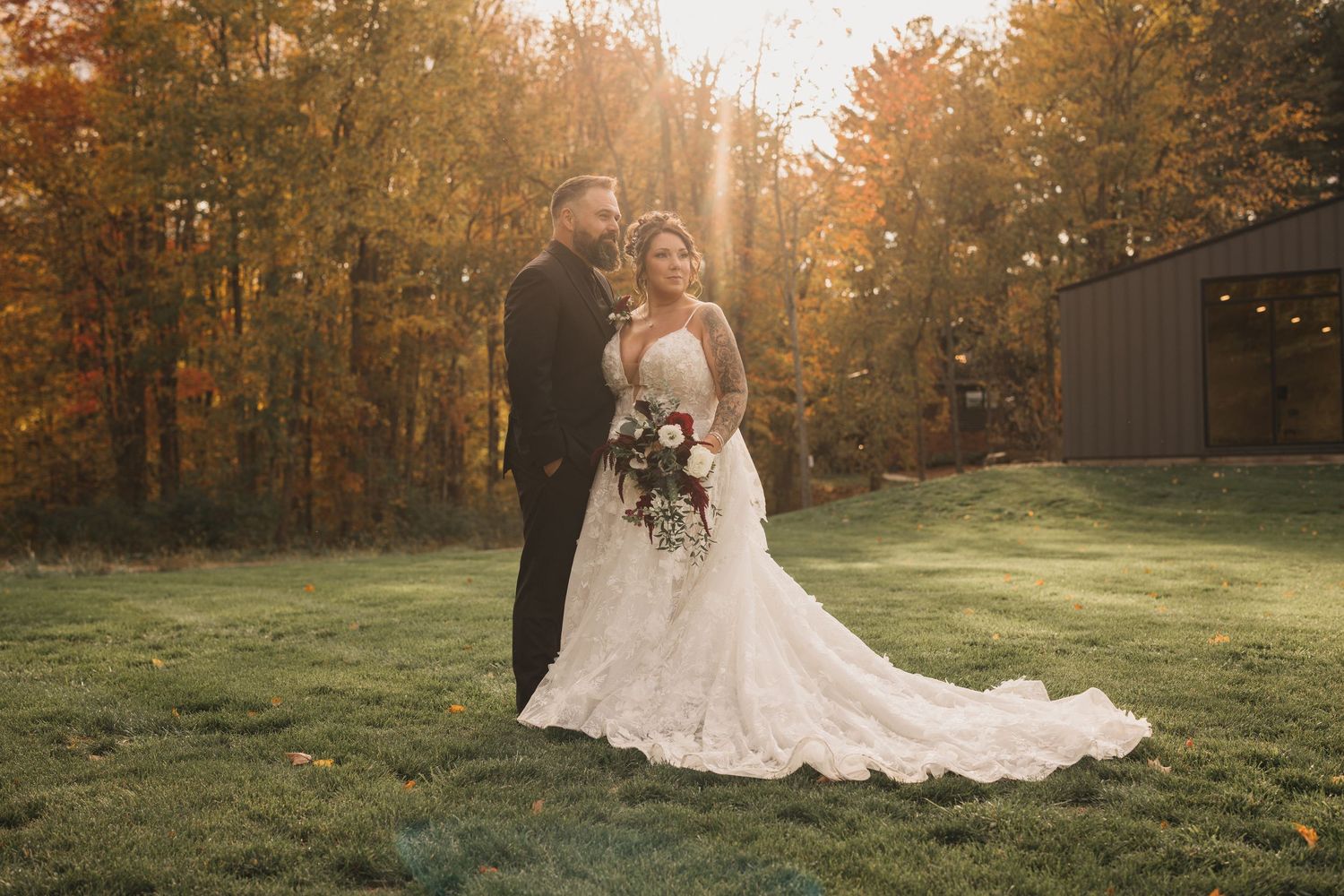 Wedding couple photographed in golden hour light against rustic outdoor setting.