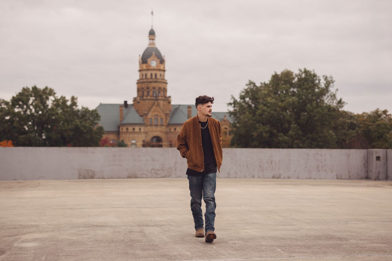 Person walking on rooftop with historic dome building visible in cloudy background.