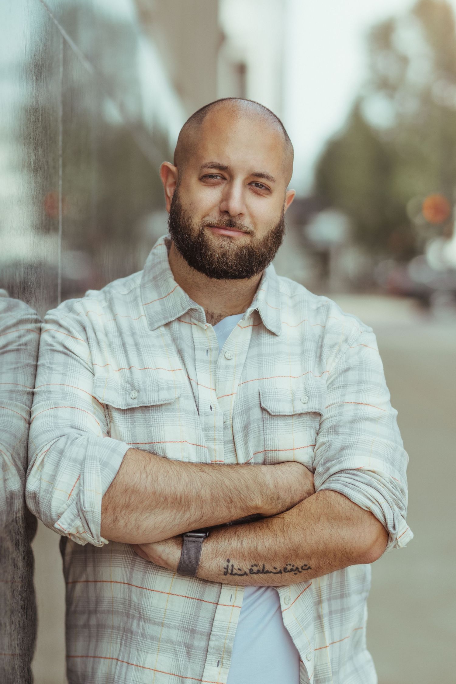 Casual portrait series showing person in light denim shirt with crossed arms.
