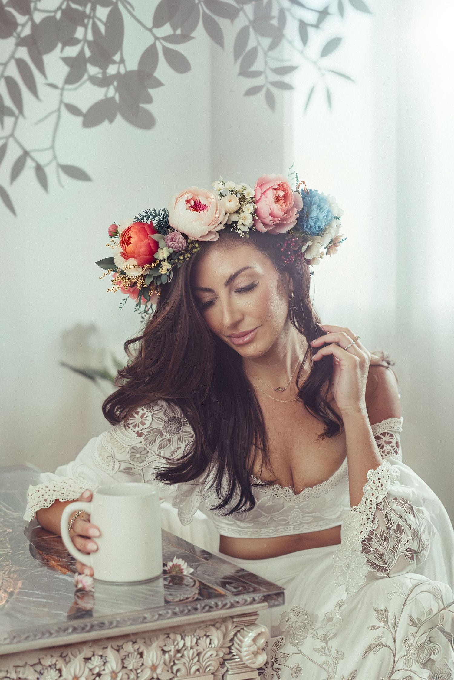 Ethereal bridal portrait with floral crown and lace dress in soft natural light.