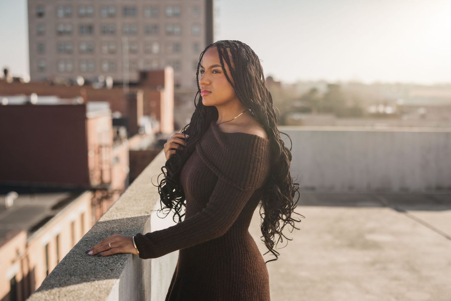Urban rooftop portrait session with city buildings in background during golden hour.