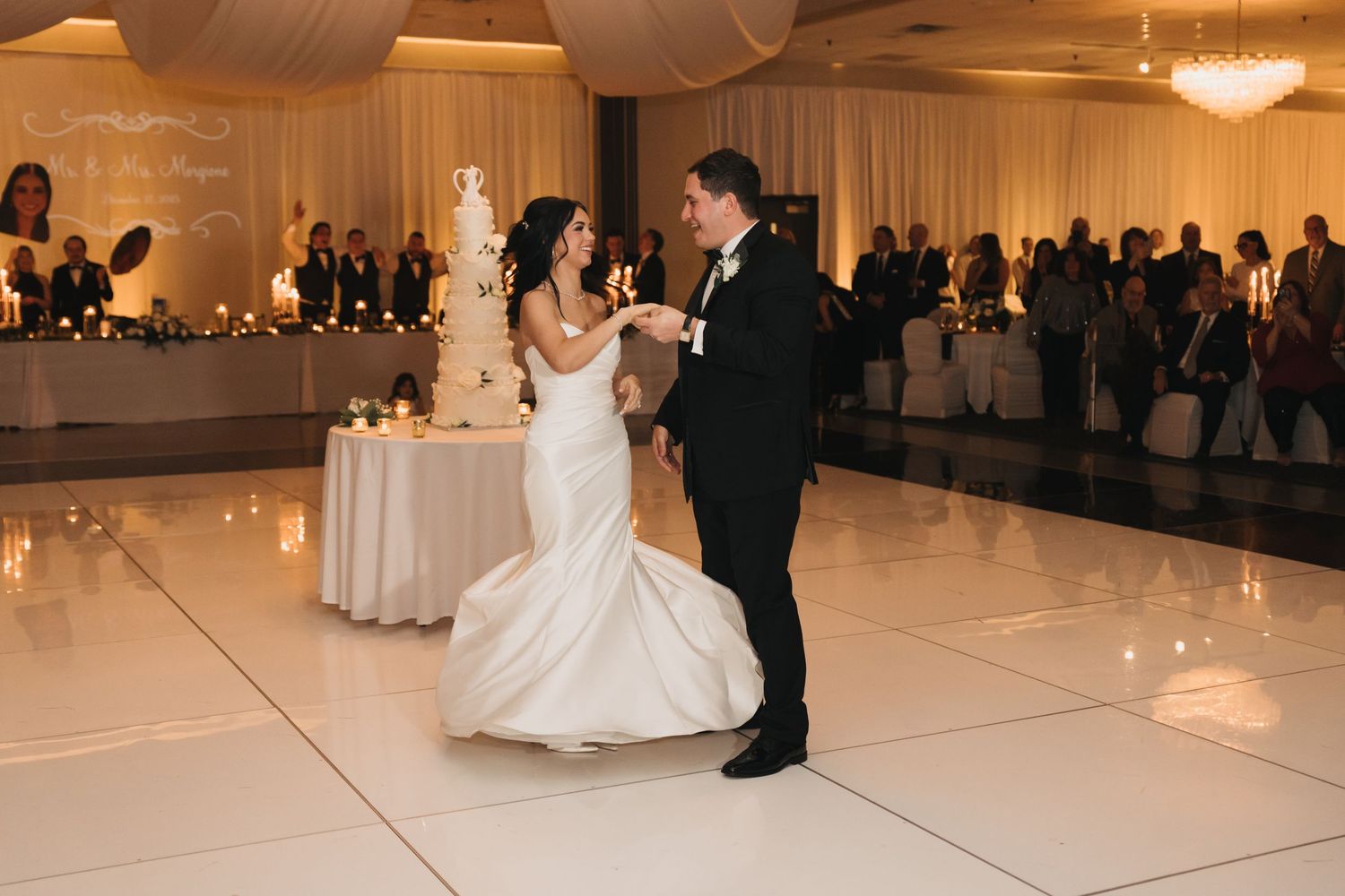 Couple dancing together at their wedding reception in an elegantly decorated ballroom.