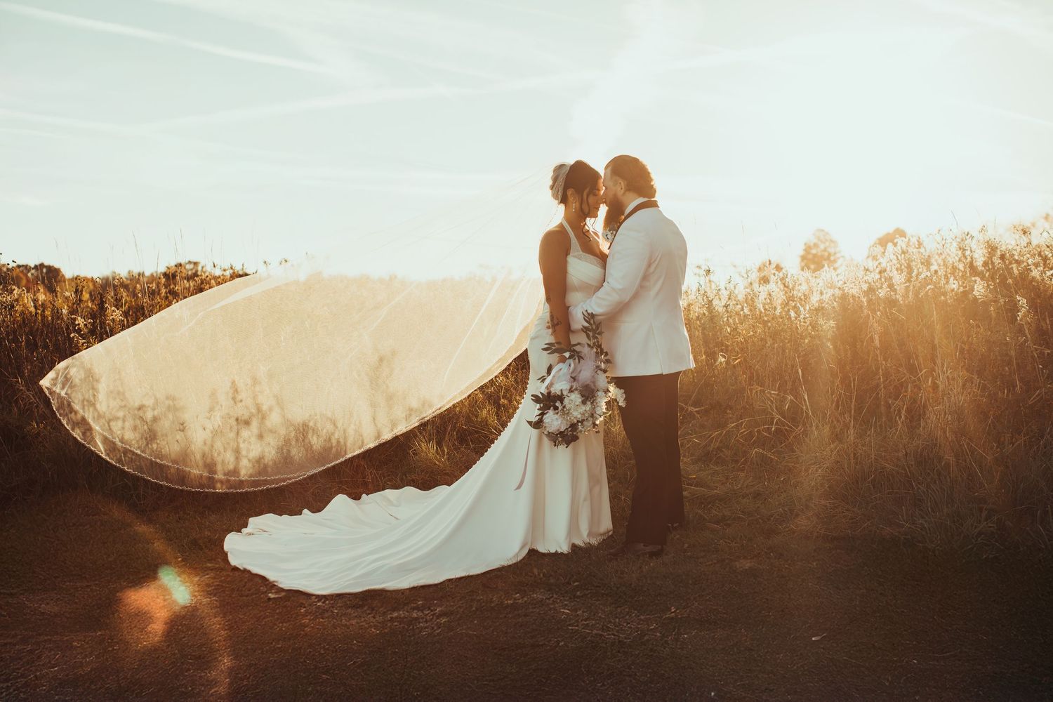 Silhouetted wedding portraits at sunset creating dramatic romantic lighting effects.