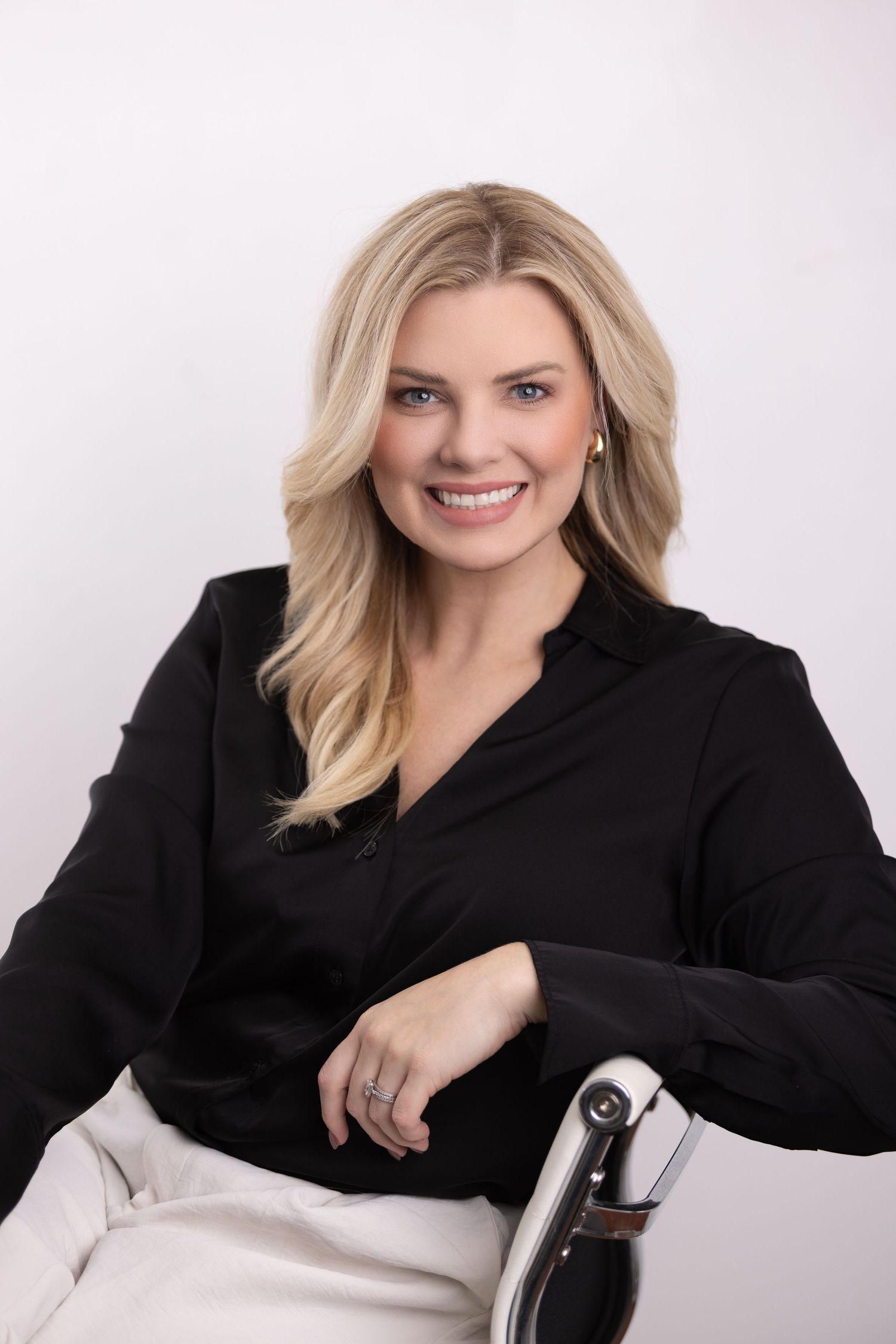 Professional headshots of person in black blazer seated against white background.