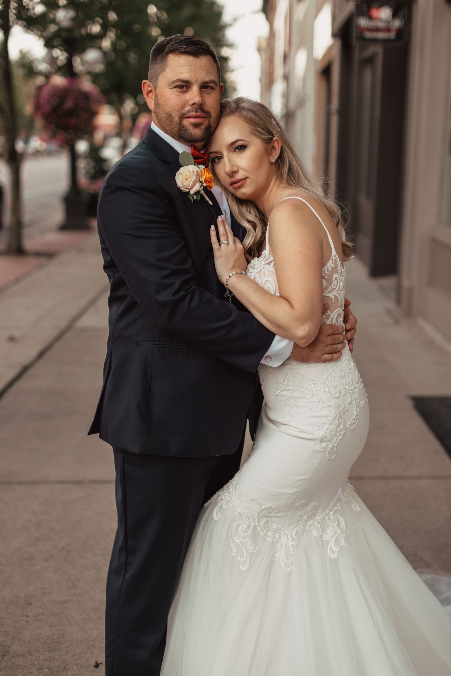A series of intimate wedding portraits showing a couple embracing on a city sidewalk.