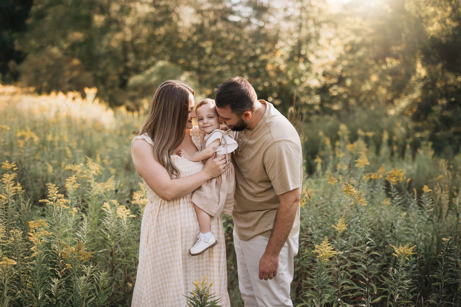 Couple sharing an intimate moment in a wildflower field at golden hour.