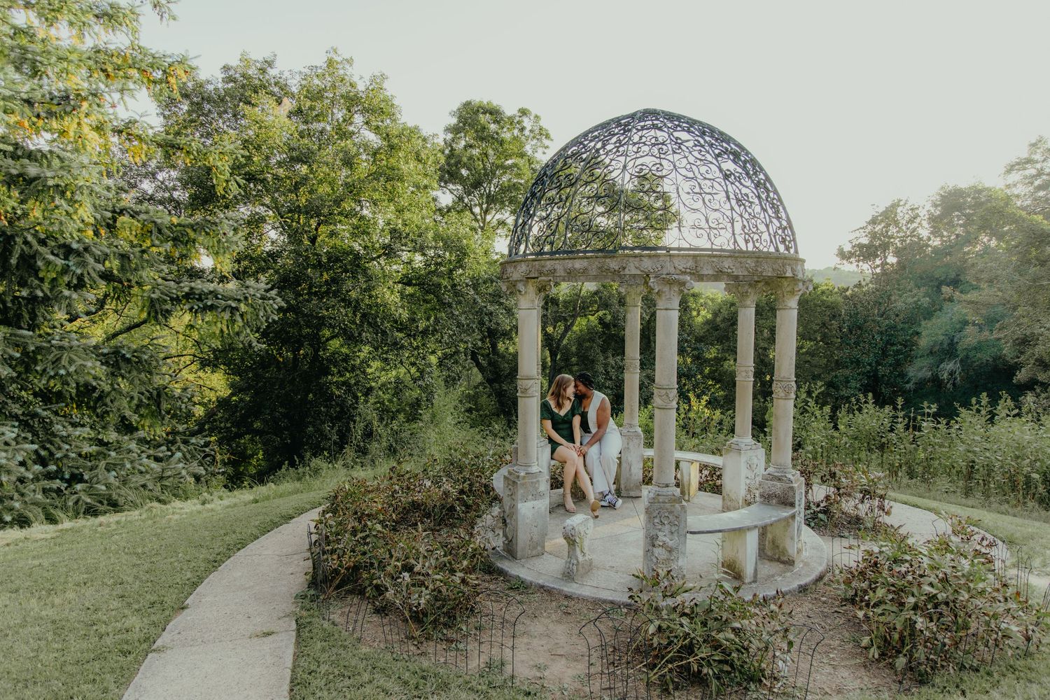 A romantic outdoor garden wedding ceremony setup with a white gazebo and chairs arranged on a manicured lawn. Engagement session at Maymont