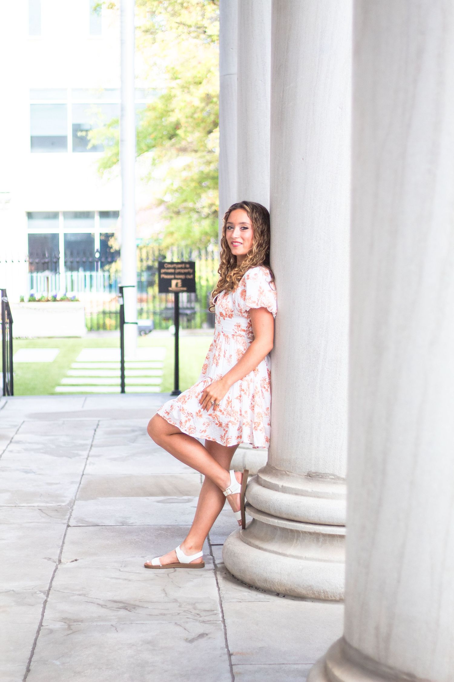 High school senior leaning against column.
