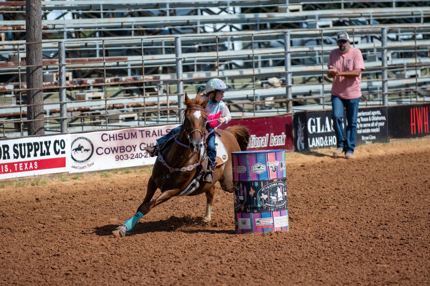Barrel racing competitor on horseback navigating around a barrel at the Chisum Trail Cowboy Classic rodeo in Texas.
