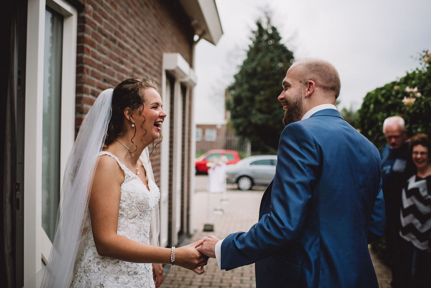 Bride and groom share a joyful first look moment outside on their wedding day.