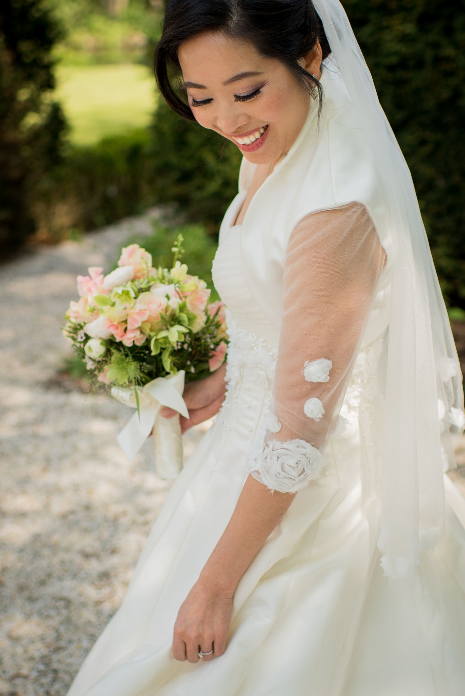 Radiant Asian bride smiles holding pink and white bouquet gefotografeerd door documentaire trouwfotograaf Kim van den Broek