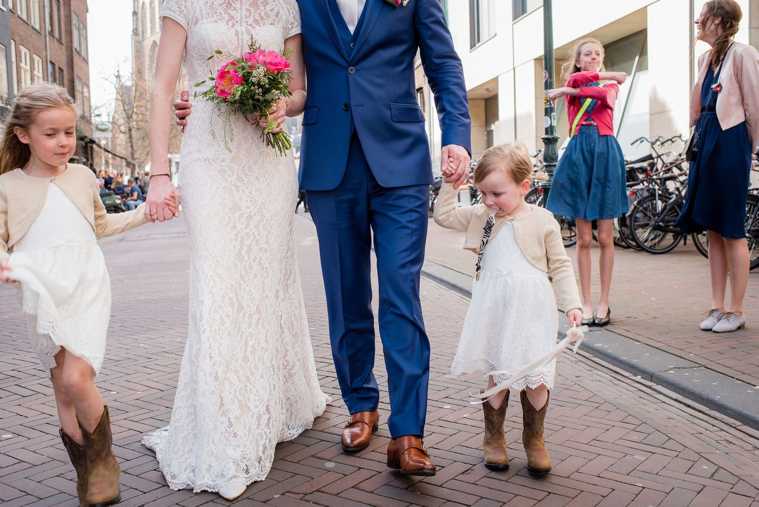 Wedding couple walking with two young flower girls gefotografeerd door documentaire trouwfotograaf Kim van den Broek