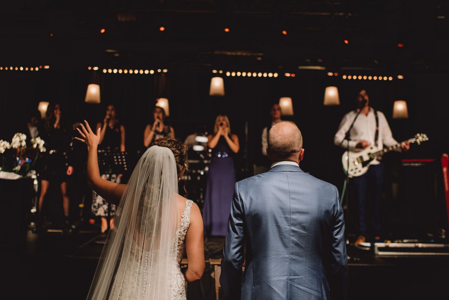 Bride and groom stand before a live band during an emotional wedding ceremony celebration. Door Kim van de Broek Fotografie