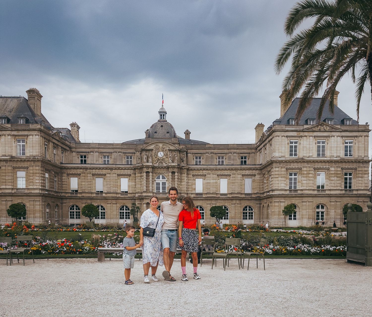Family posing in front of the Luxembourg Palace in Paris, France.