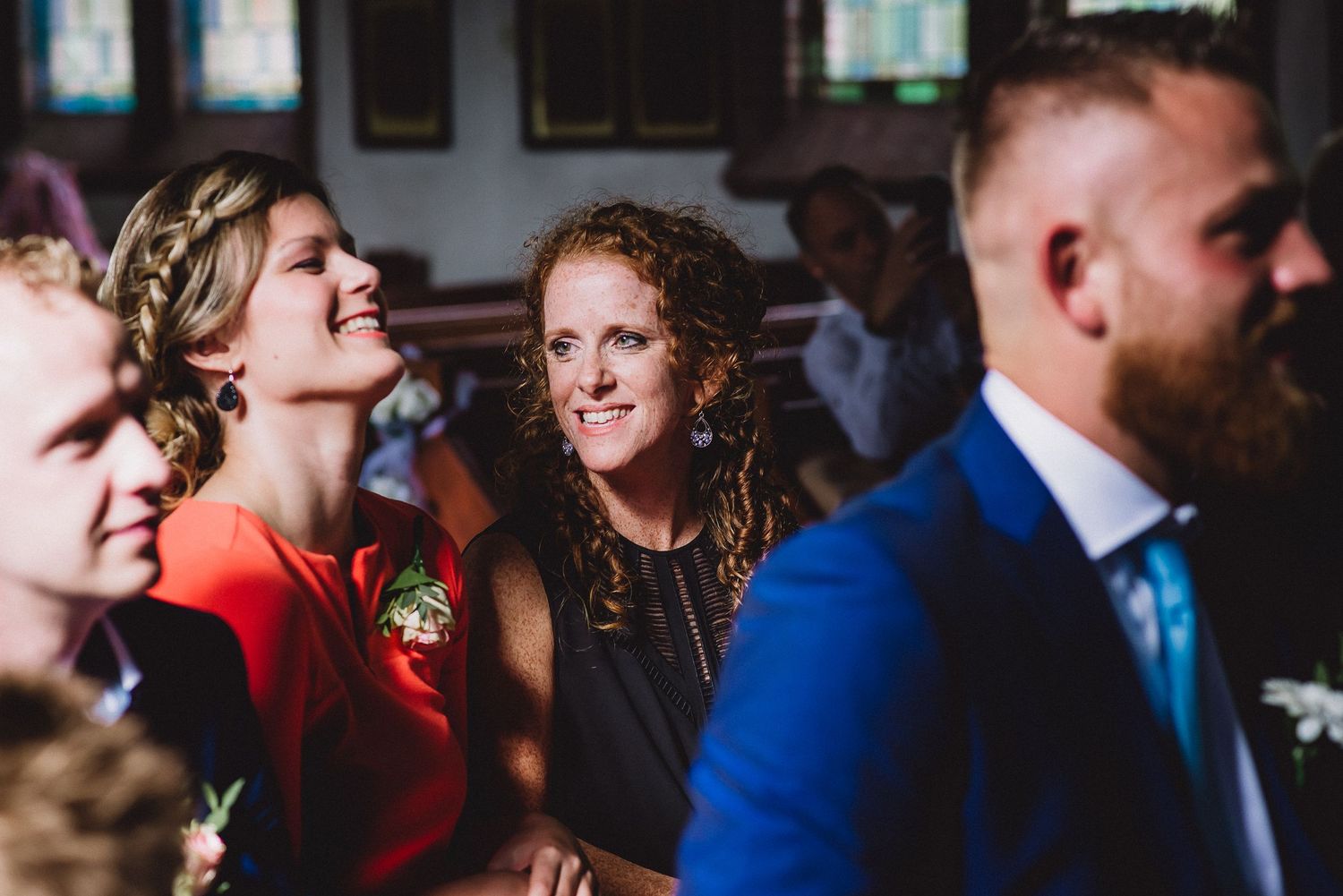 Wedding guests laughing and smiling joyfully during a church ceremony celebration. Door Kim van den Broek gefotografeerd