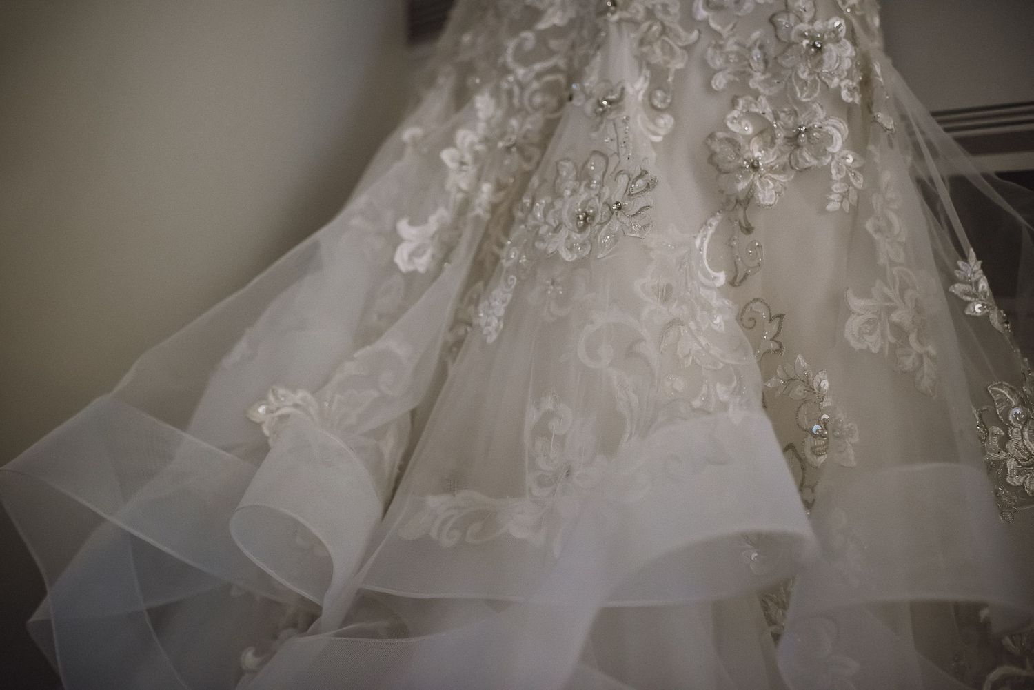 Close-up detail of an ornate lace and floral embroidered bridal wedding gown train.