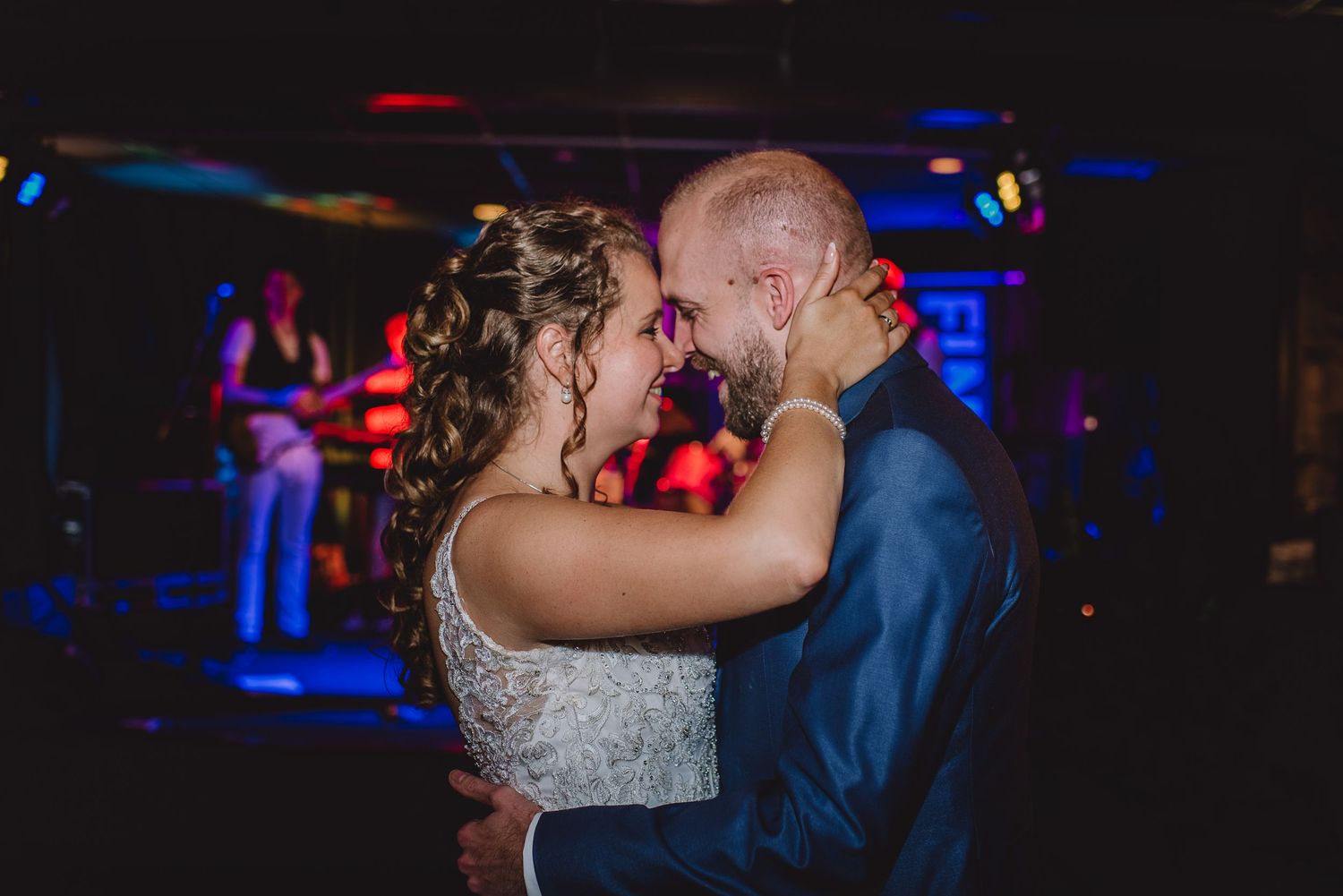 Couple sharing an intimate first dance with a live band performing in the background.Door Kim van de Broek Fotografie