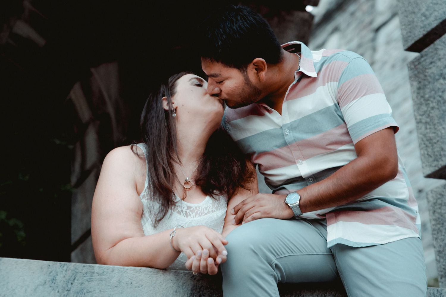 A kiss is shared between a newly engaged couple while the bride-to-be shows off her engagement ring in Valhalla, NY.