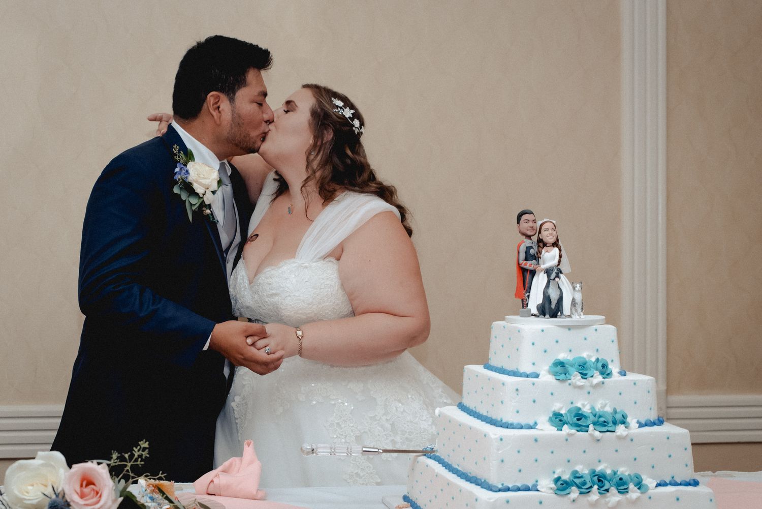 A bridge and groom share a kiss after cutting their wedding cake at their wedding venue in Westchester, NY.