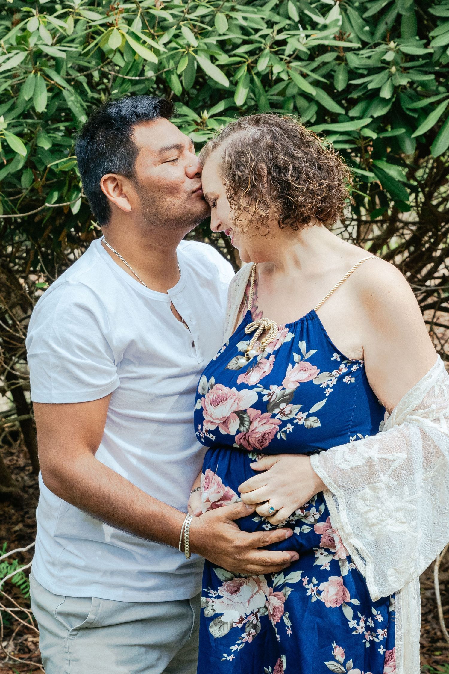 A sweet forehead kiss between husband and wife. Both parties's hands are on the wife's belly for this maternity session in Hartsdale, NY.
