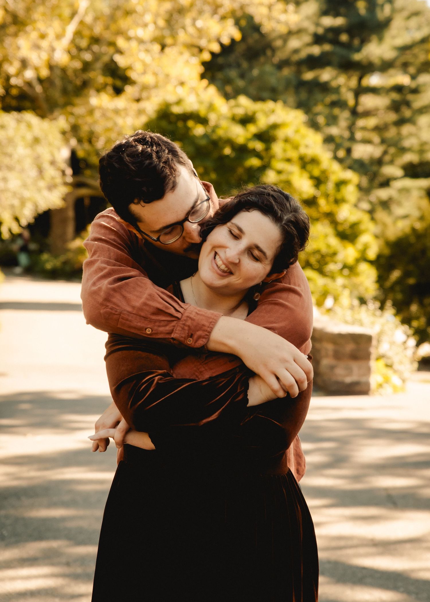 A couple hugging in Fort Tryon Park in New York during an engagement photo session