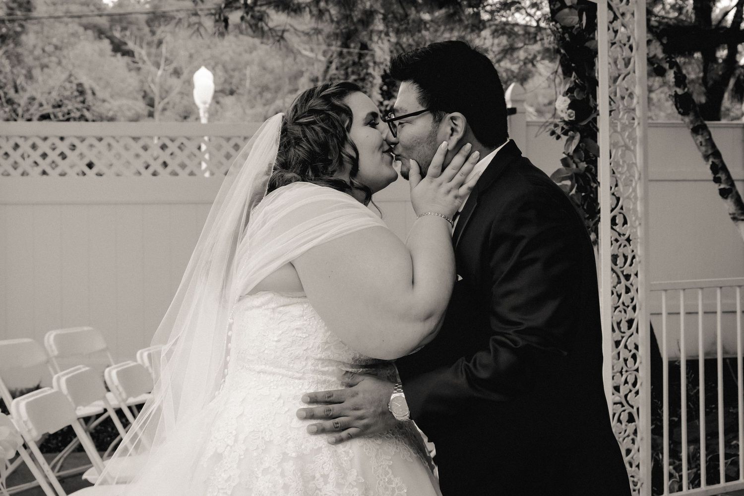 Black and white portrait of the bride and groom embraced and sharing a passionate kiss at their Westchester, NY wedding.