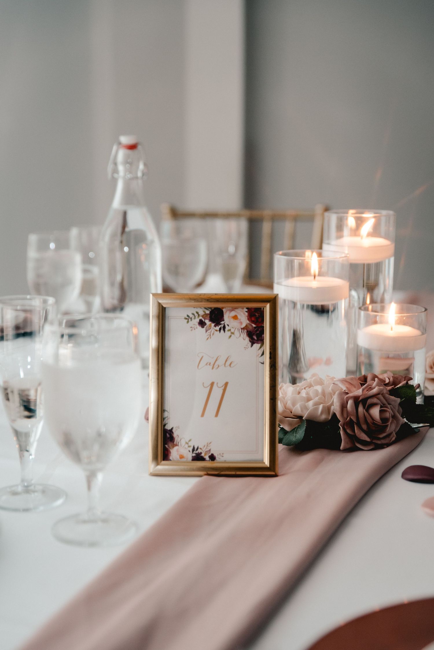 Details of the place settings for guests including roses and three candles as the centerpiece at the Riverdale in Endicott, NY.