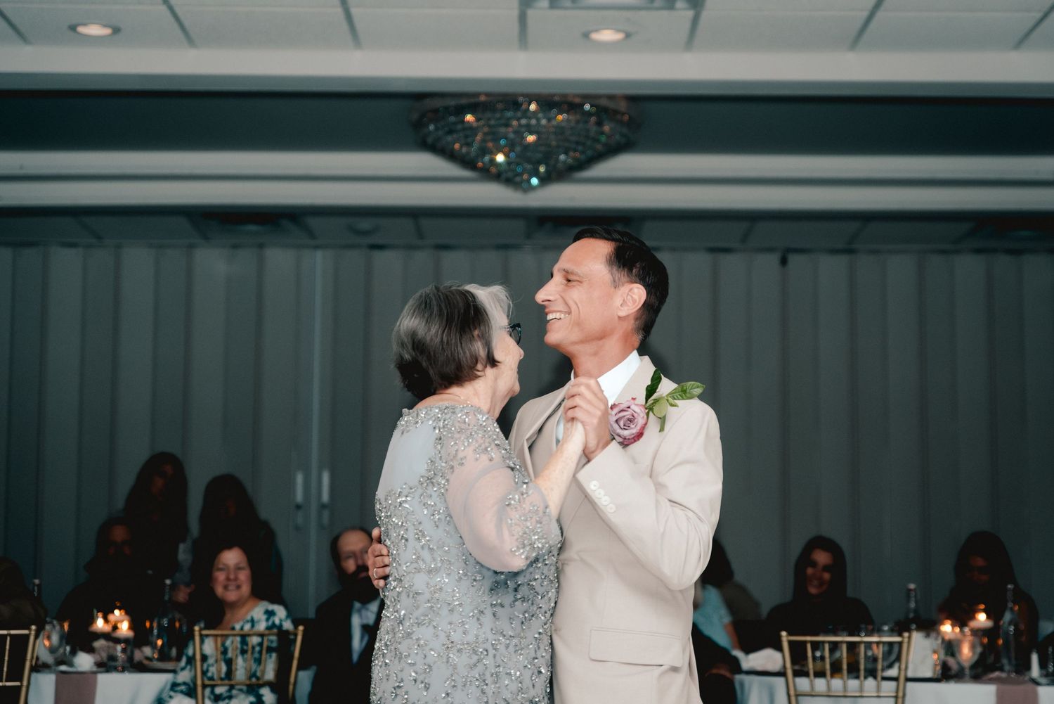 The groom shares a dance with his mother at the Riverdale in Endicott, NY. Everyone is smiling and cherishing the once-in-a-lifetime moment.