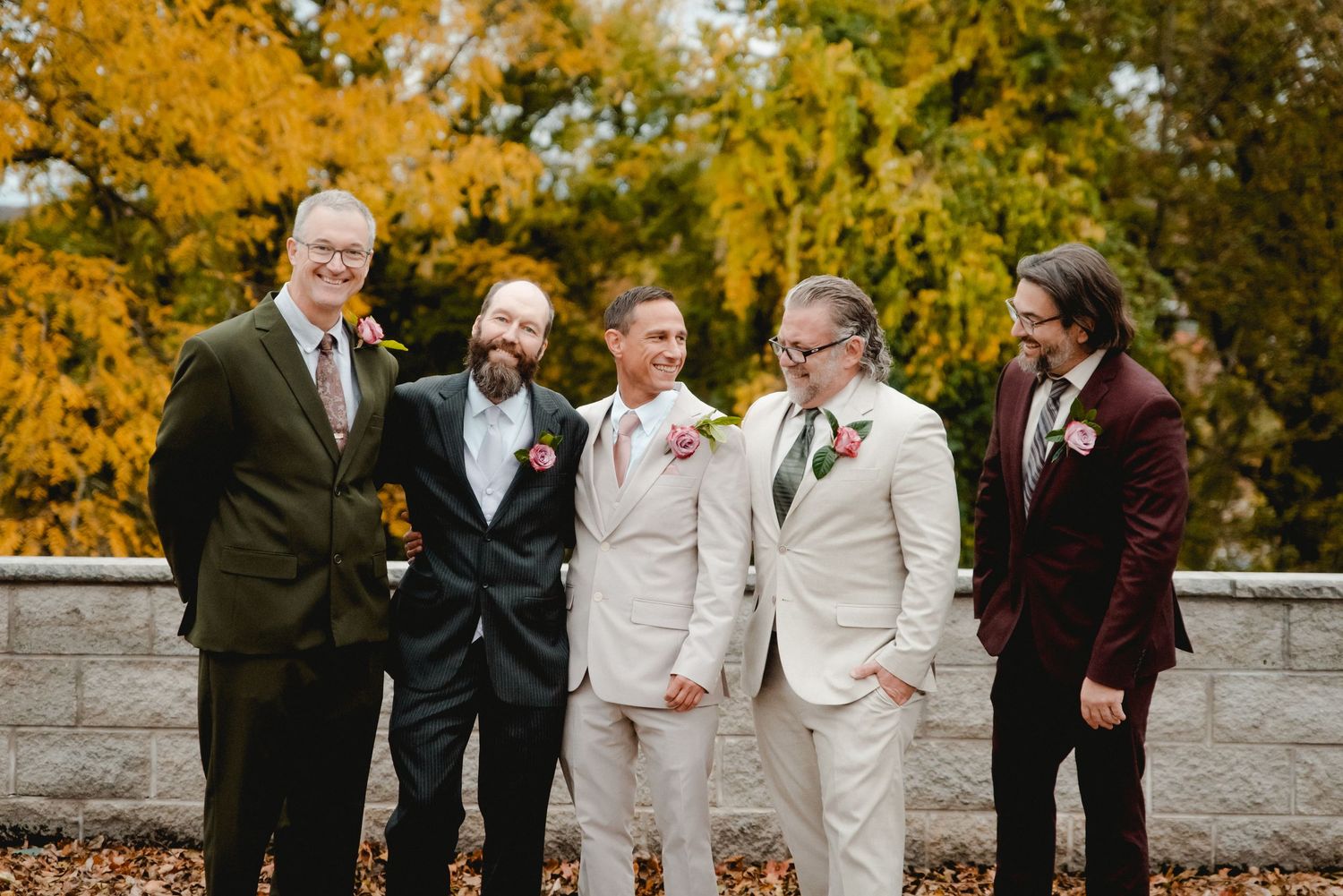 The groom and his groomsmen sharing a candid moment while taking photos on a stunning fall day in Vestal, NY.