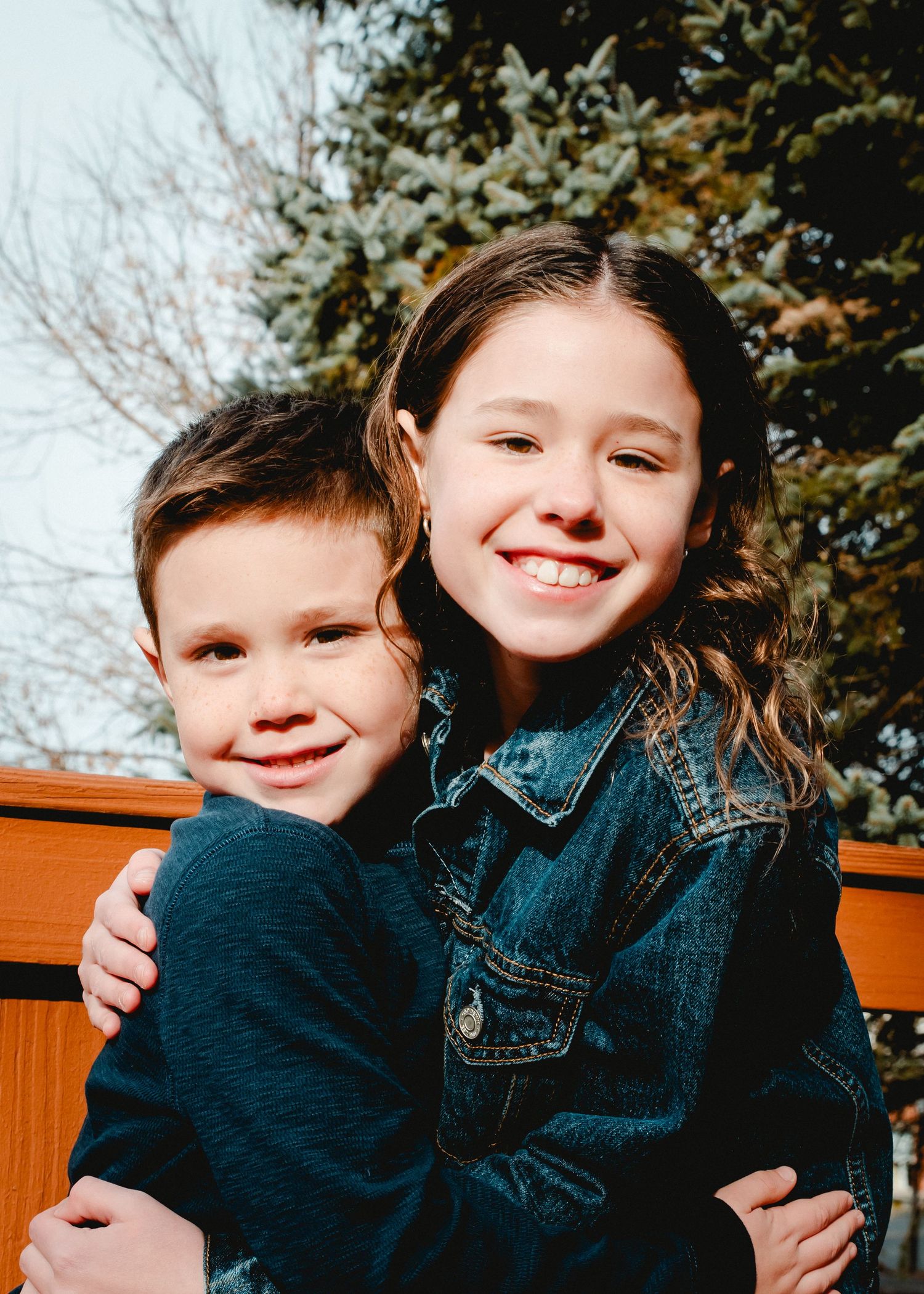 A close up of a brother and sister taken during a family session in Westchester, New York. Both kids are smiling at the camera.